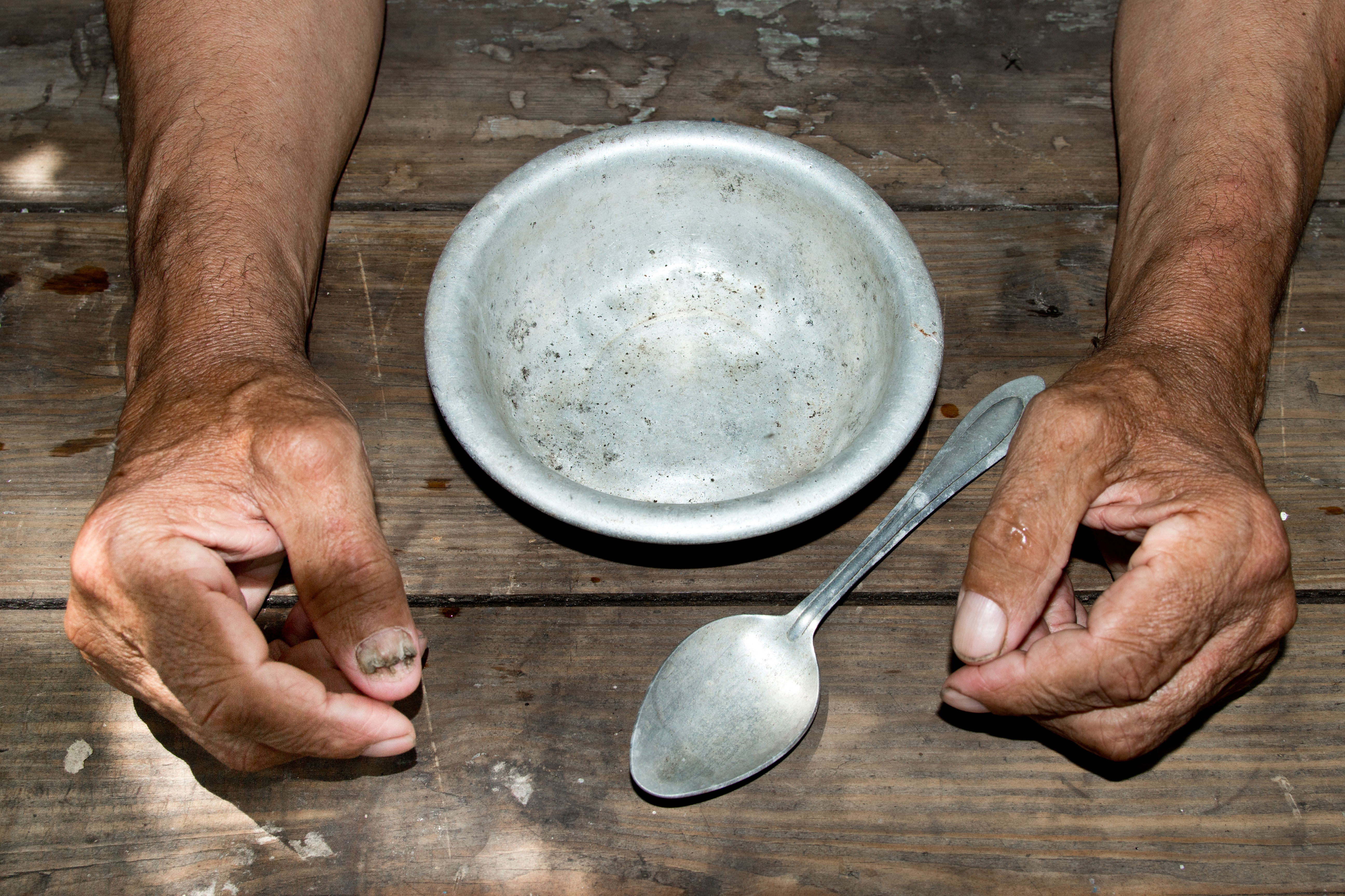 hands the poor old man's and empty bowl on wood background. The concept of hunger or poverty. Selective focus. Poverty in retirement.Homeless.  Alms
