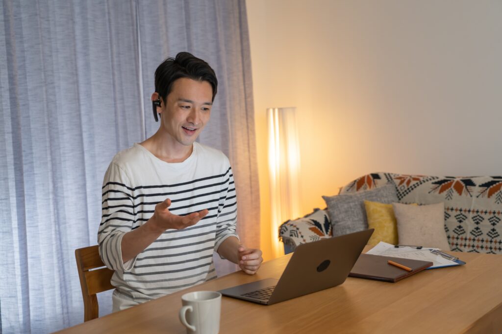 夜にパソコンで英会話のレッスンを受ける男性のイメージ