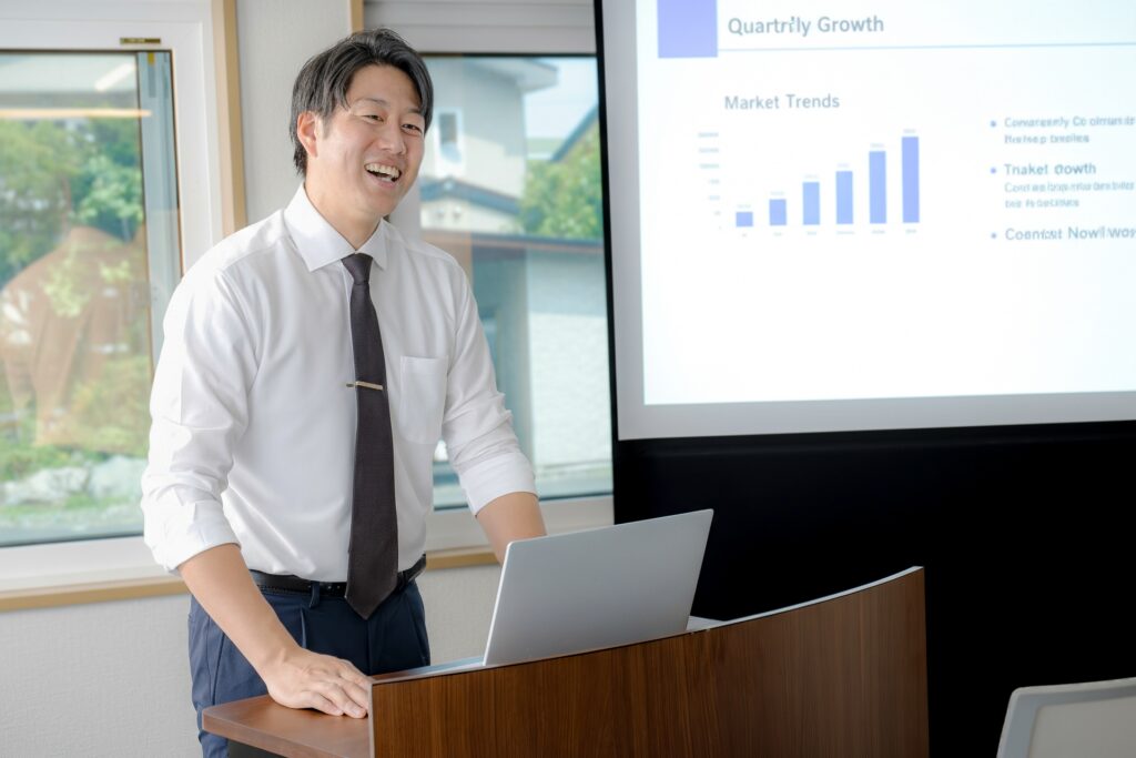 英語でプレゼンをする、シャツにネクタイをした若い男性のイメージ