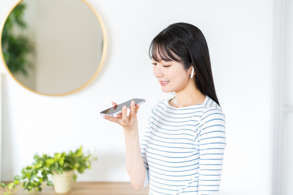 スマートフォンで英語のシャドーイングをする女性のイメージ